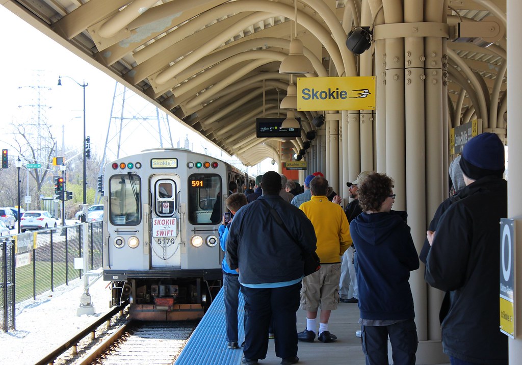 Skokie Swift CTA Yellow Line train arriving at Dempster Street Station in Skokie IL with commuters on platform