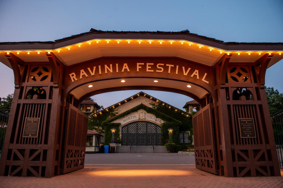 Ravinia Festival Highland Park IL | MacLagan Home Loans Ravinia Festival entrance gate lit up at dusk in Highland Park IL with Martin Theatre visible in the background